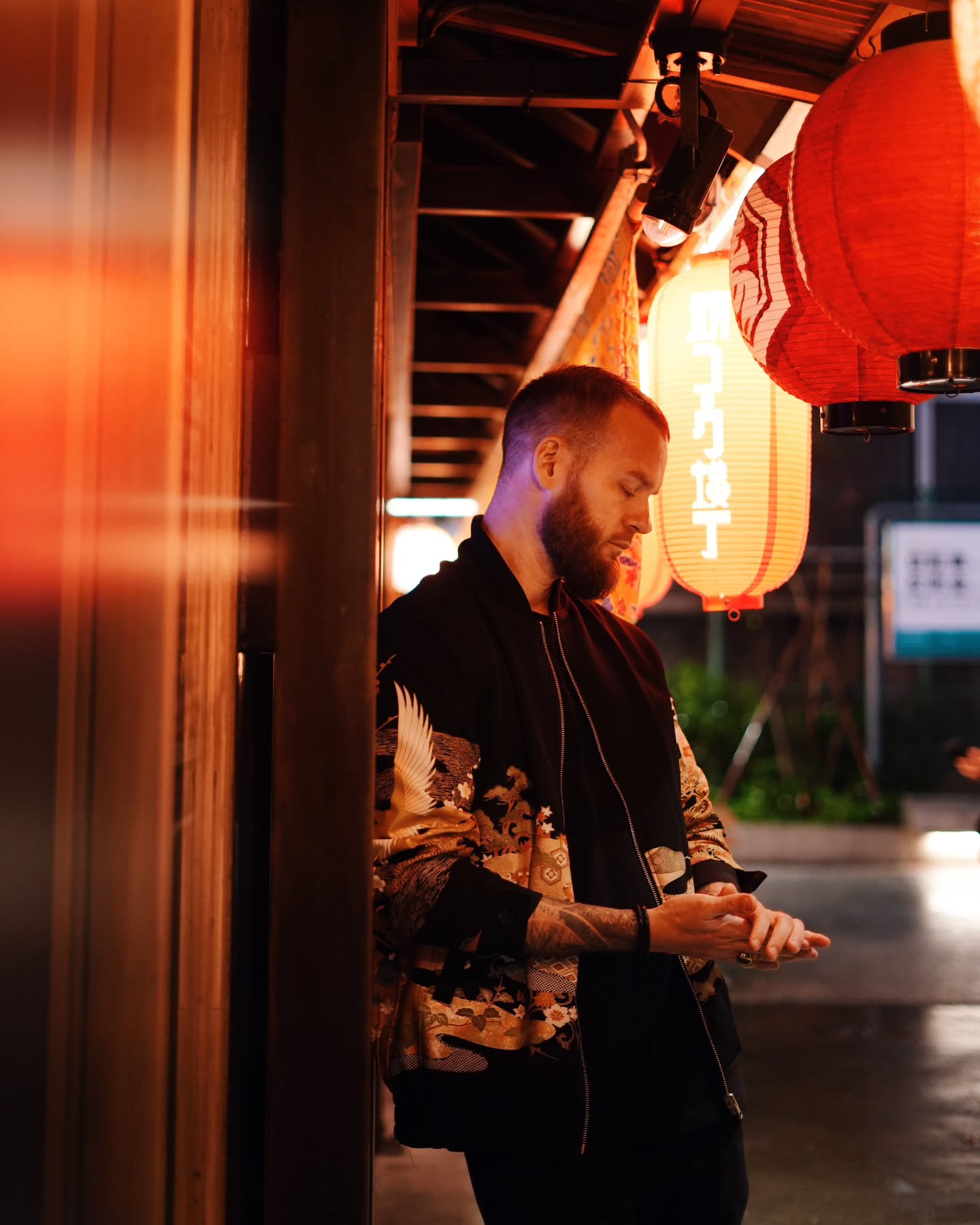 Arnaud Bruckler dans une ruelle de restaurants au Japon, le soir, sous des lanternes