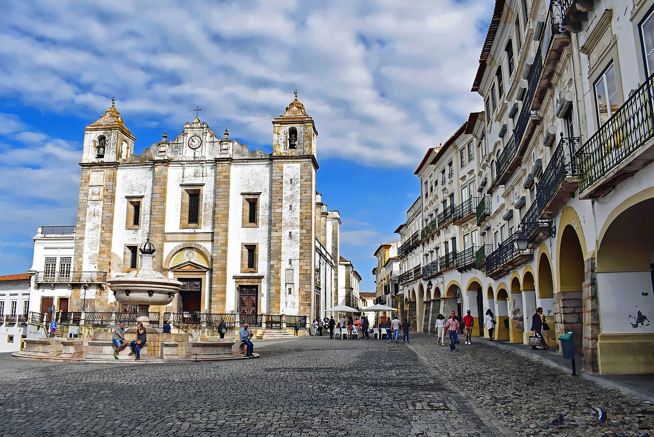 La place du Giraldo à Évora, sa fontaine de marbre, l'église Santo Antão et les arcades